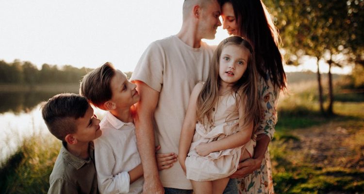 Family enjoying quality time together outdoors by the lake during sunset.